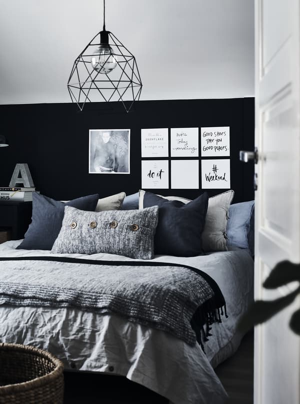 A bedroom decorated in grey, black and blue.