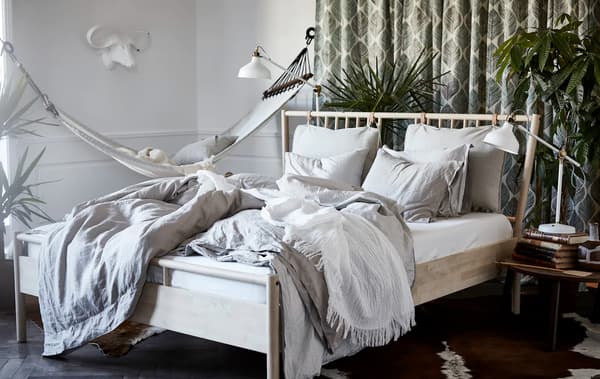 A bedroom with a BJÖRKSNÄS bed frame, RANARP lamp and STOCKHOLM coffee table