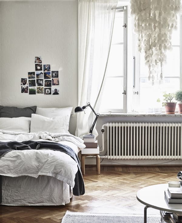 A bedroom with wooden floor and neutral decor.