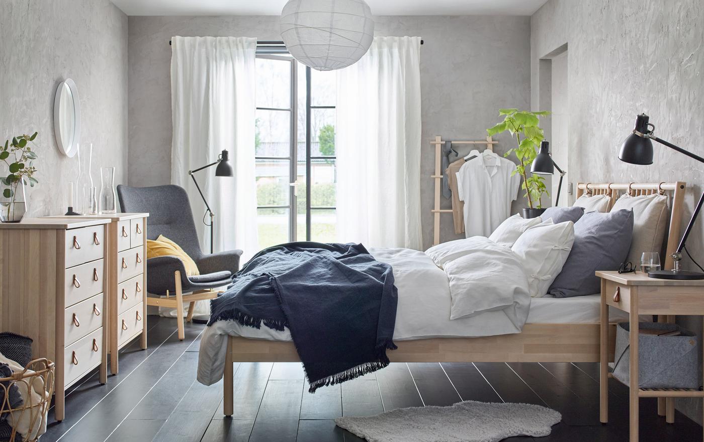 A beige and grey bedroom with BJÖRKSNÄS bed, bedside table and chest of 5 drawers made from solid birch wood.