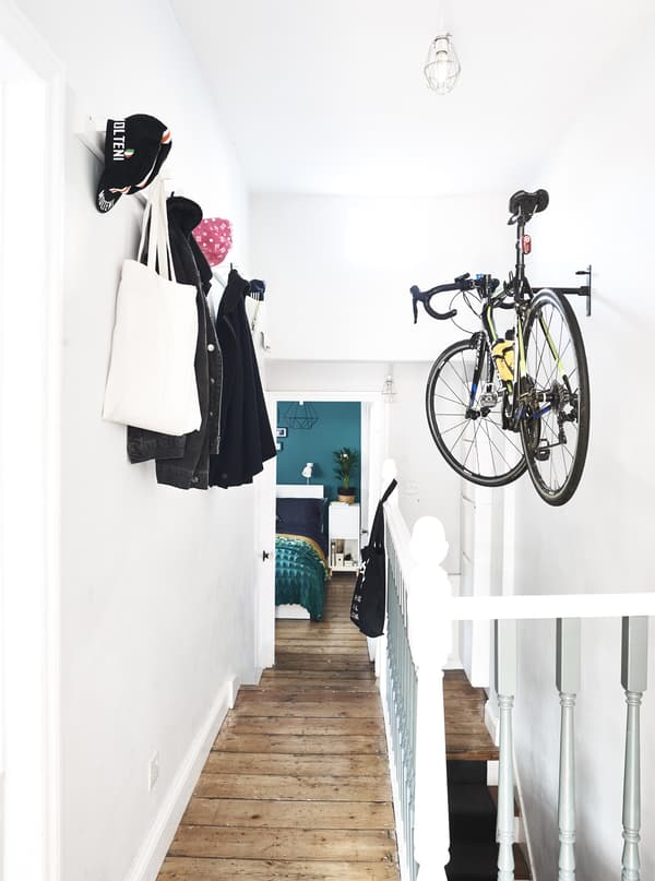 A bike and coats hanging up in a hallway.