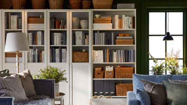A BILLY cabinet in the lviing room filled with books and accessories.