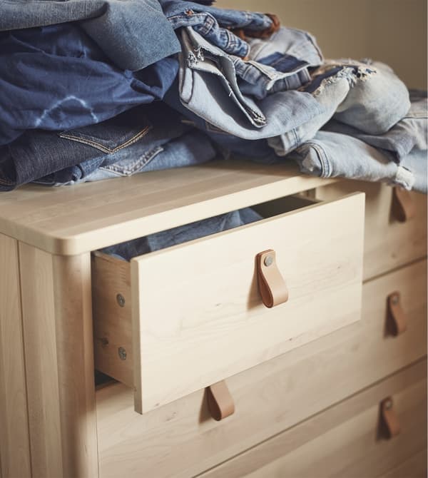 A birch chest of drawers with leather handles.