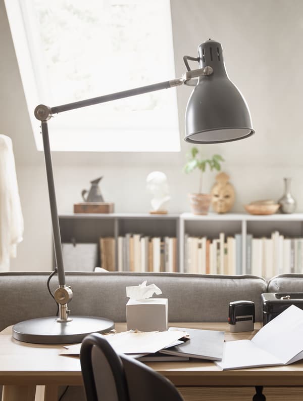 A black desk lamp sits on a desktop.