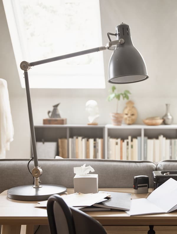 A black desk lamp sitting on a desktop.