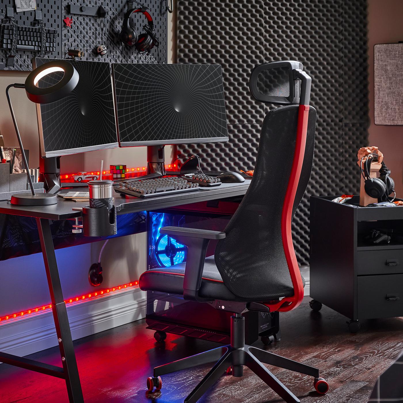 A black UTESPELARE gaming desk with two screens, a black gaming chair, a black drawer unit and various gaming accessories.