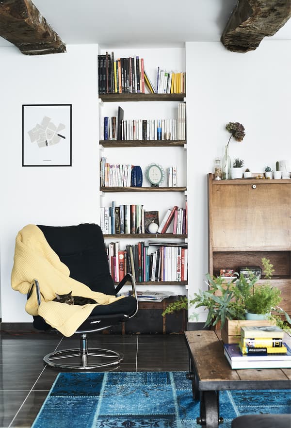A black vintage IKEA swivel chair with yellow throw.