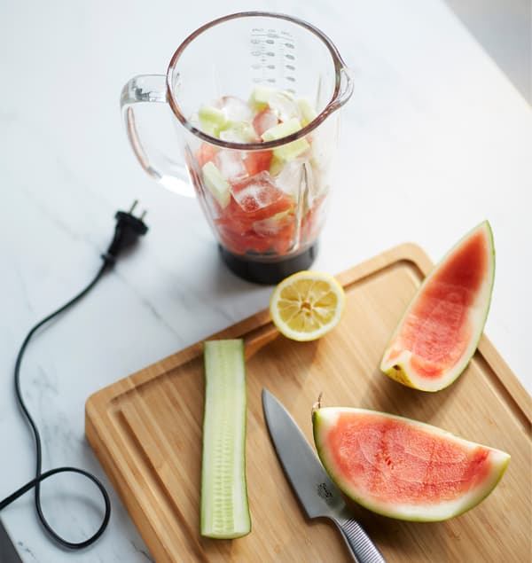 A blender filled with smoothie ingredients sits on a countertop.