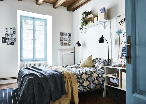 A blue and white bedroom with yellow accents.