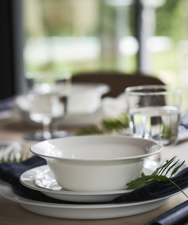 A bowl and plates laid out on a wooden table.