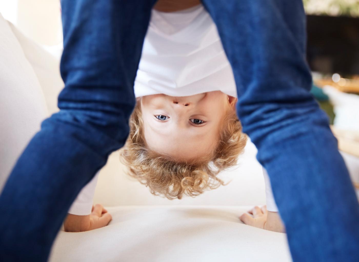 A boy standing on all fours on a white couch while playing, symbolising product safety at IKEA.