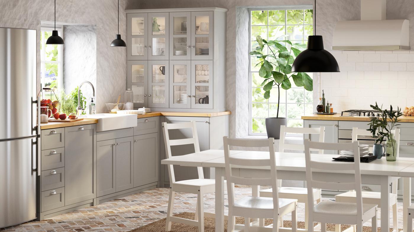 A bright kitchen in traditional style with light-grey LERHYTTAN kitchen fronts, NORDVIKEN table and five chairs in white.