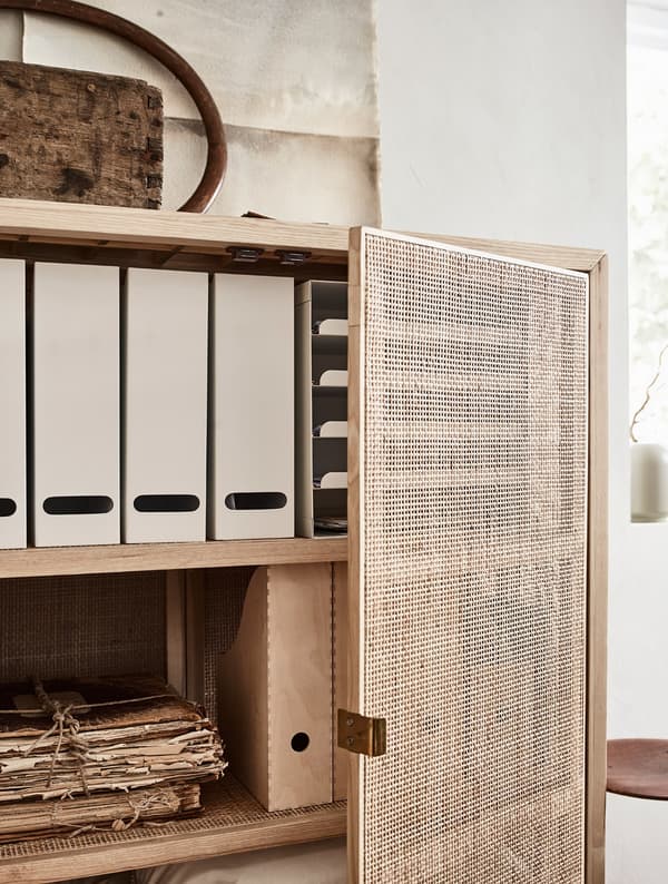 A cabinet holding magazine files, papers and extra bed linen.