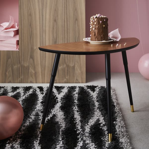 A cake on a LÖVBACKEN side table on a black and white rug.