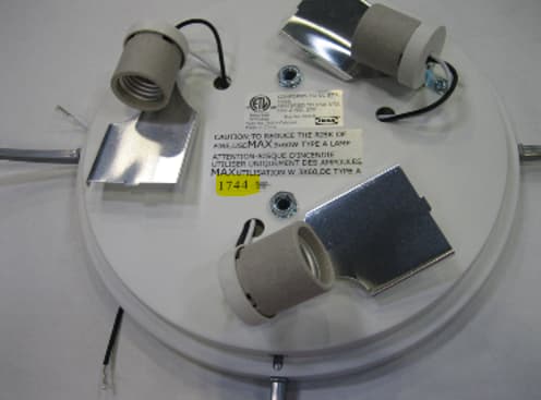 A ceiling lamp without the shade, exposing the three electrical bulb sockets.
