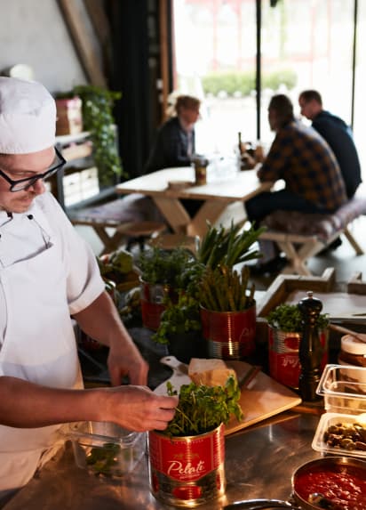 A chef at Barkhult restaurant picks fresh herbs.