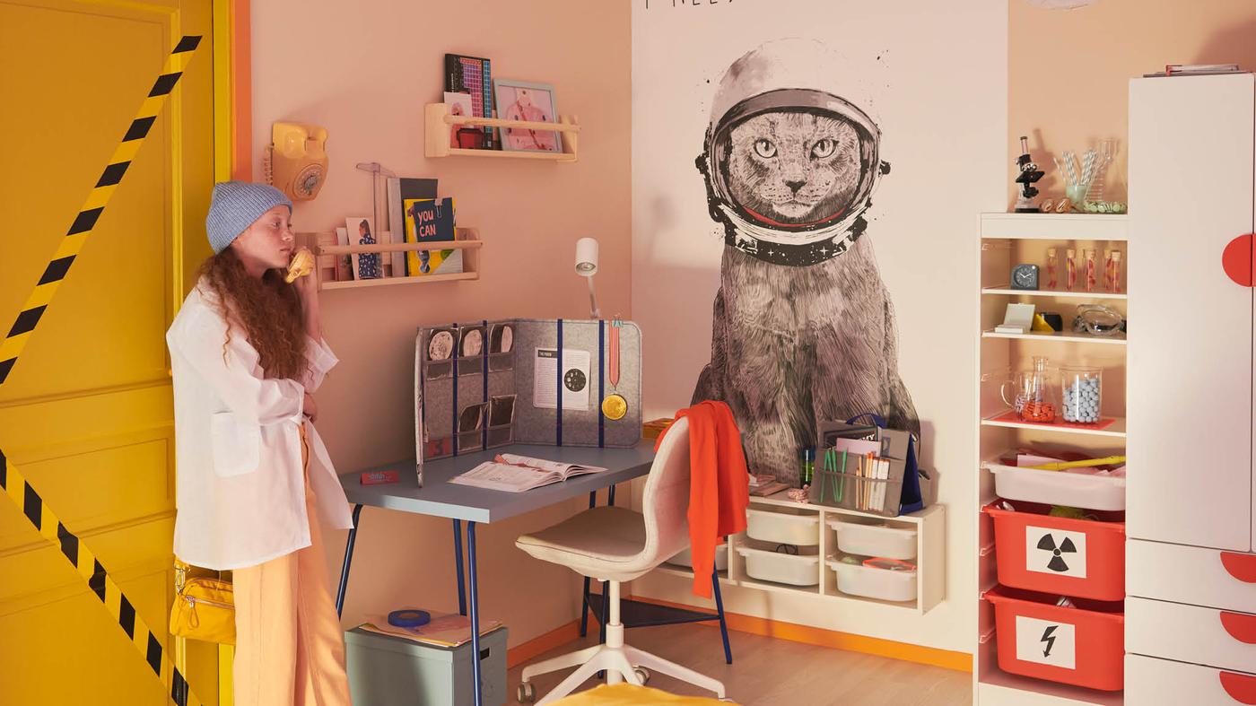 A child standing by the door looking at her room.