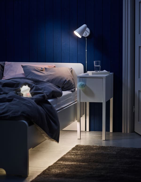 A children’s bedroom lit with an IKEA FUBBLA wall lamp in white.