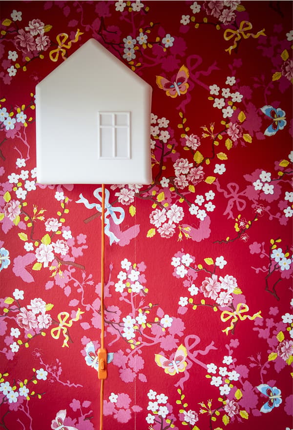 A child’s lamp on a red wall.