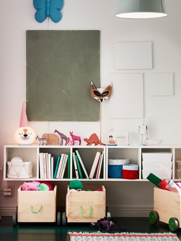 A child’s nursery bedroom with IKEA FLISAT storage boxes on wheels and SMÅGÖRA modular wall storage with toy animals.