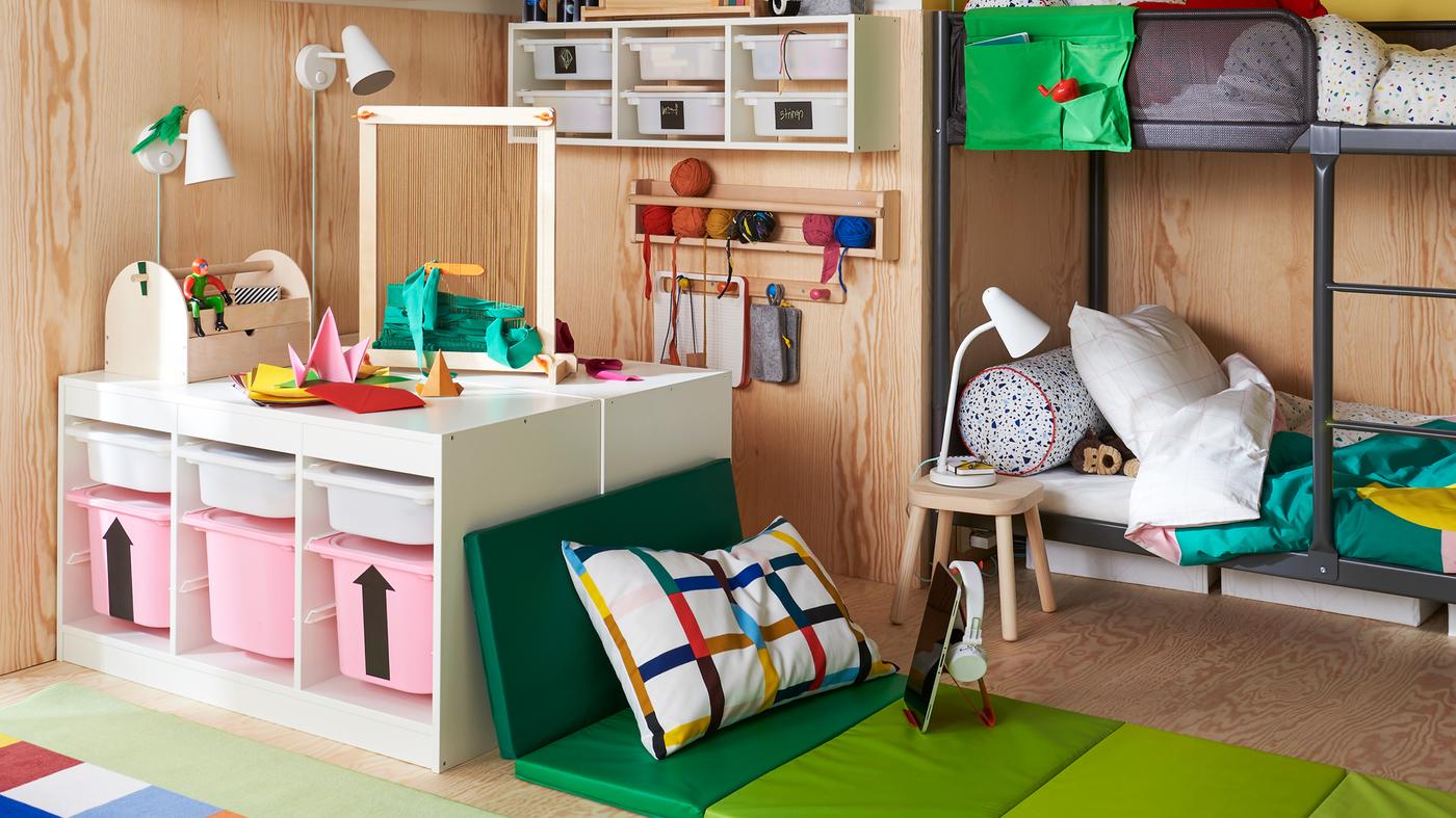 A child’s room with a TUFFING bunk bed, TROFAST storage and a soft seating area with a PLUFSIG folding gym mat.