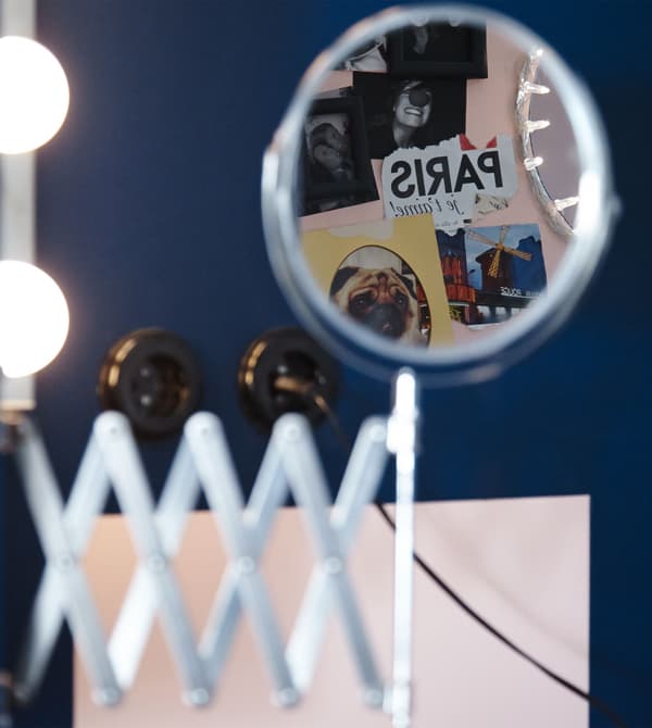 A close-up image of an IKEA GRUNDTAL cart stocked with blowdryers, curling irons, and other accessories.