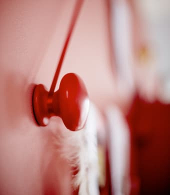 A close-up image of an IKEA NORRBYN knob strung with string to hang artwork.