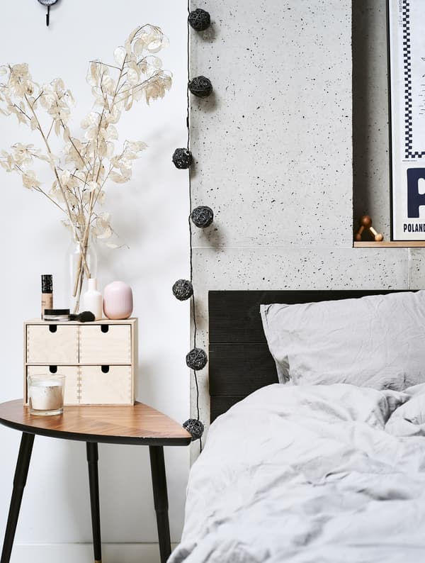 A close up of a bed and side table.