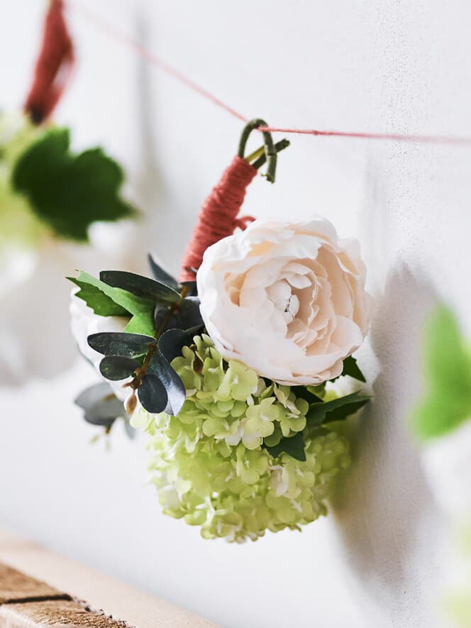 A close up of a floral arrangement hung along a wall 
