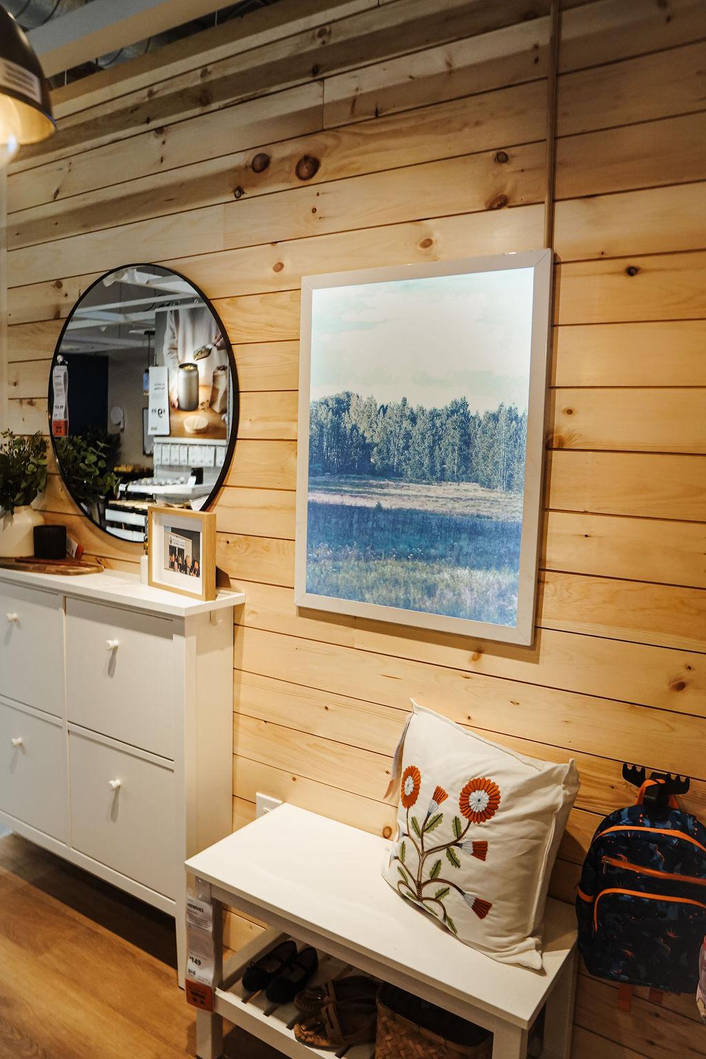 A close-up of a room setting with a colorful picture hanging on a wall with wooden slats.