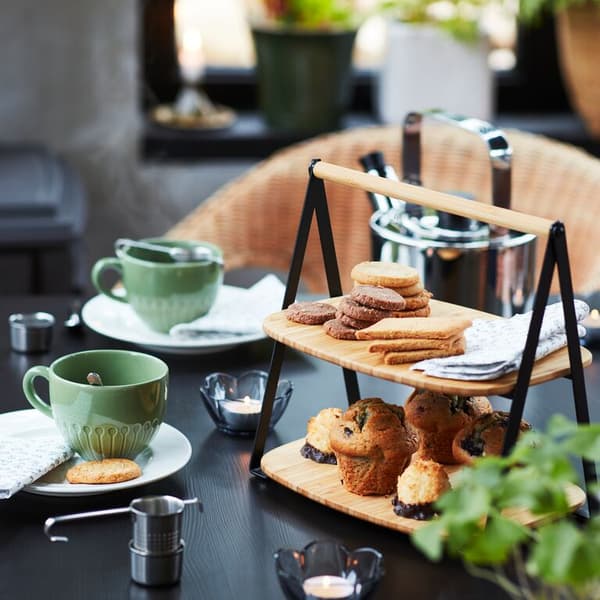 A close up of a table set for afternoon tea with a FULLSPÄCKAD serving tray and STRIMMIG mugs.