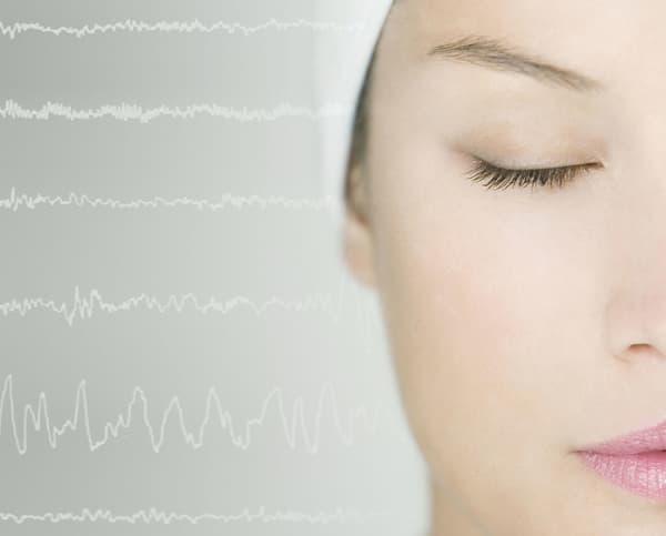 A close up of a woman's face with sound waves behind.