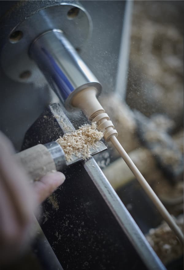 A close-up of a woodturning machine in use.