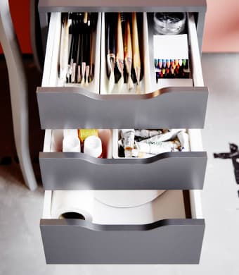 A close-up of an IKEA ALEX drawer unit storing work supplies.