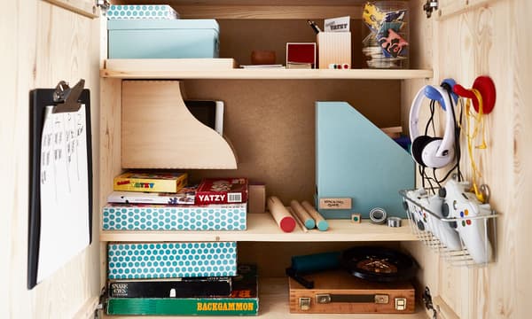 A close-up of an organized IVAR cabinet that contains lots of games, boxes and entertainment.