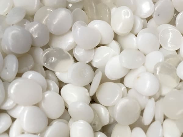 A close-up of white and transparent PLA plastic pellets, made from renewable based materials.