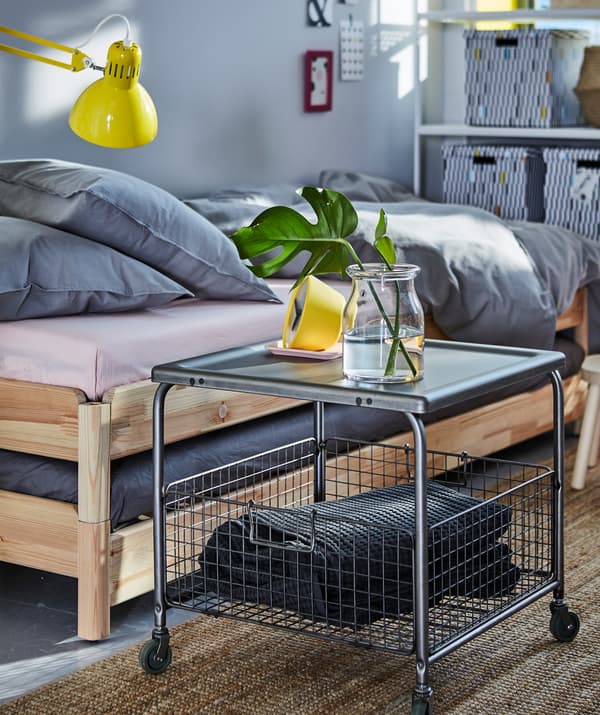 A coffee table with a spacious open wire basket underneath storing a pillow
