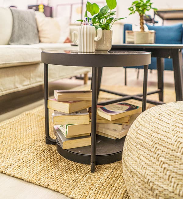 A coffee table with books placed on the bottom.