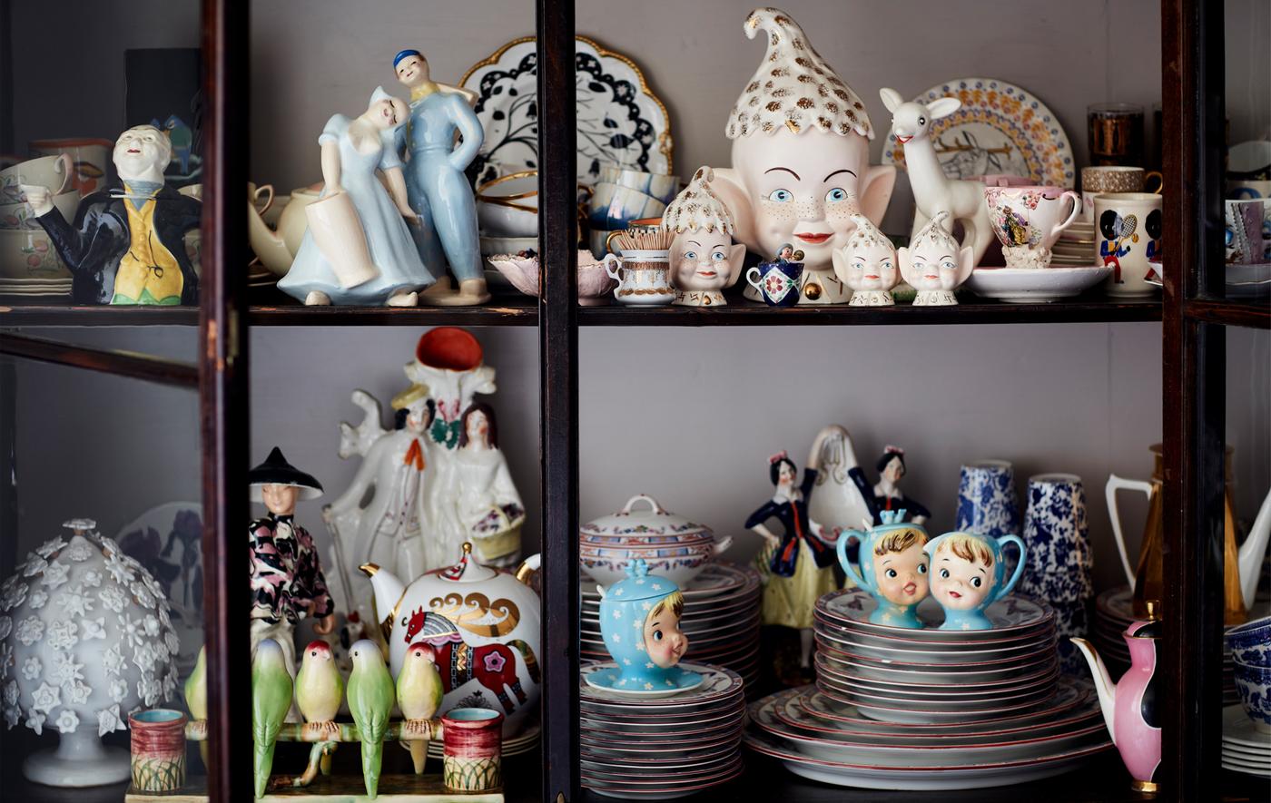A collection of china ornaments in a glass-fronted cabinet.