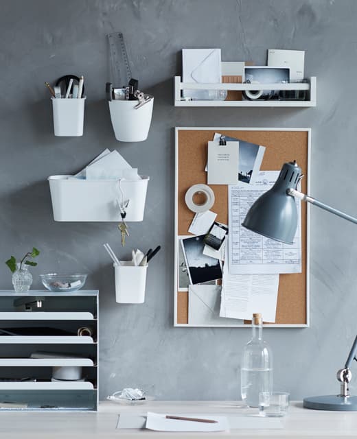 A college dorm room organizing idea showing a desk with wall organizers and a corkboard for messages.