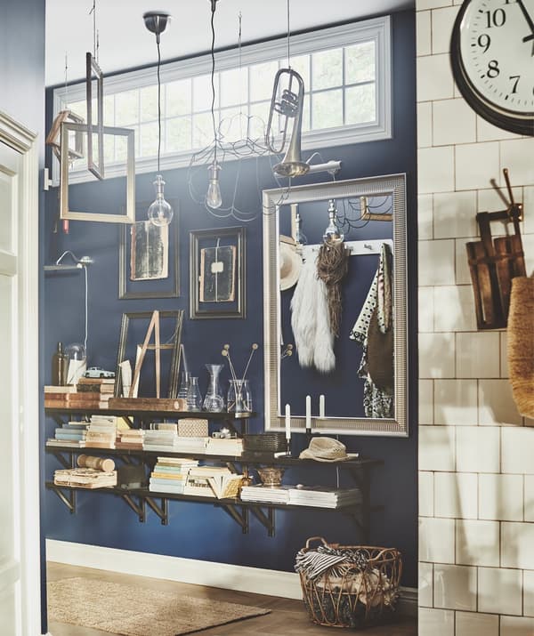 A corridor decorated with wall shelves, frames and hanging musical instruments.