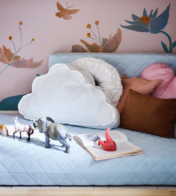 A cosy play area for a child made with cushions and a mattress for an extendable bed.