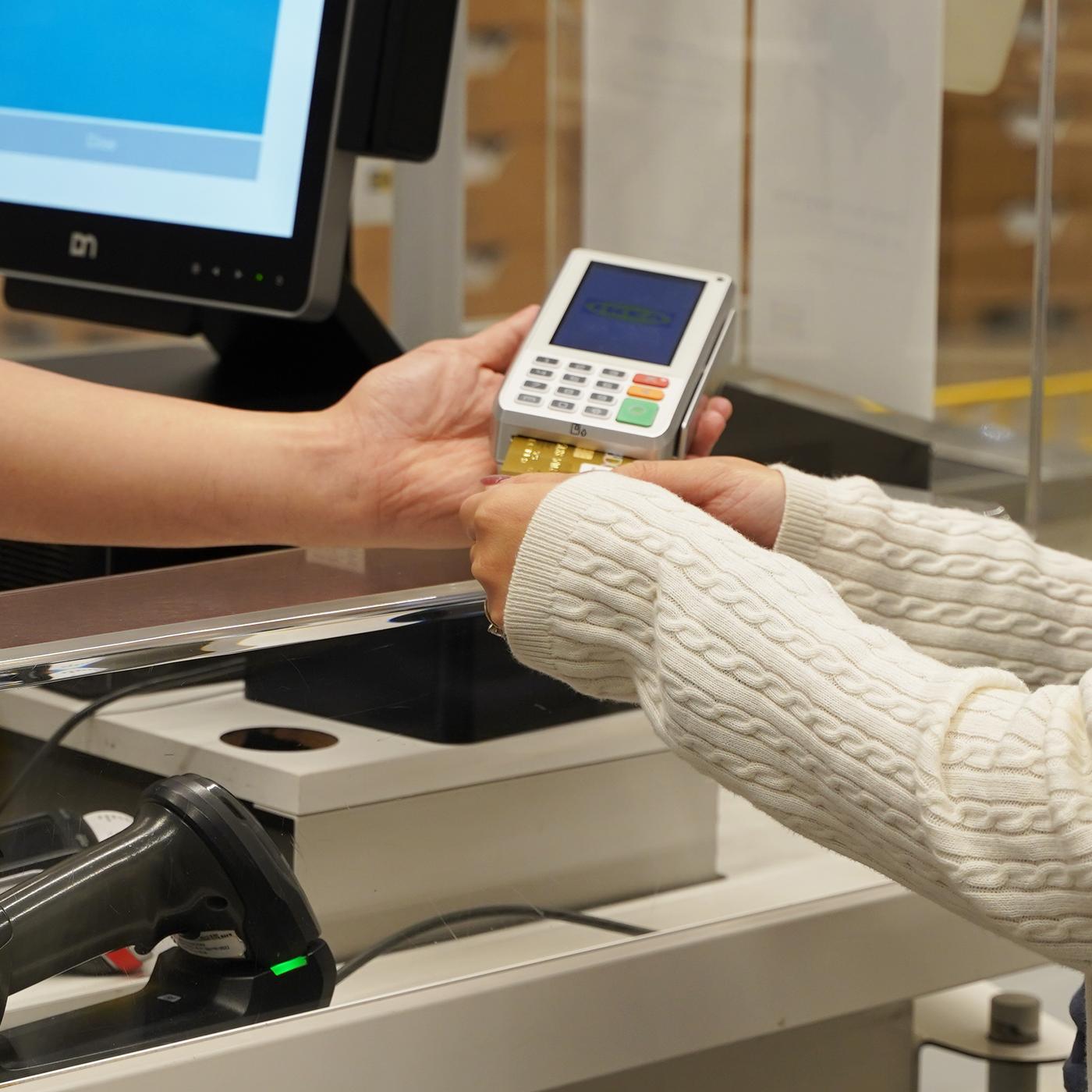 A customer making payment in a card terminal using card payment option with the help of our IKEA co-worker