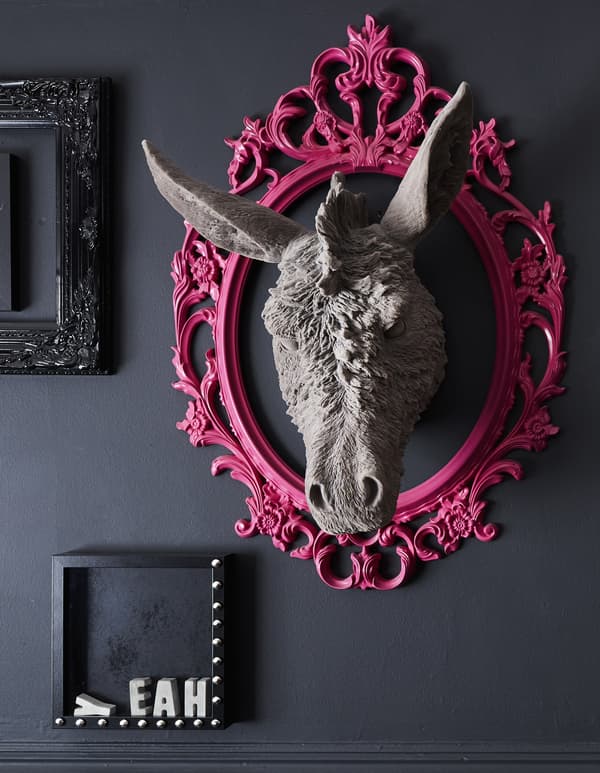 A customised bright pink frame on a black wall.