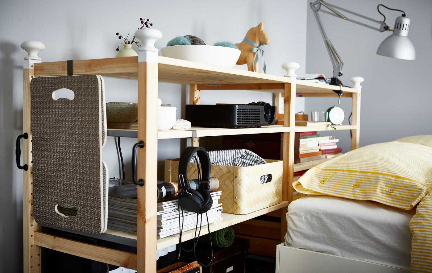 A customised IVAR shelving unit nestled behind a bed.