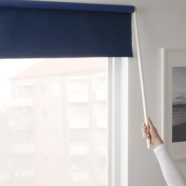 A dark blue IKEA FRIDANS blind that uses a rod that positions the blind where you want it, instead of a cord.