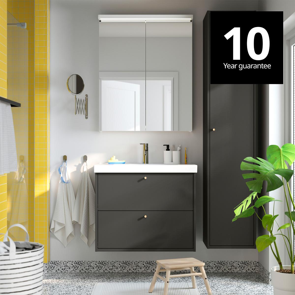 A dark grey/bamboo HAVBÄCK wash-stnd w drawers/wash-basin/tap in a bathroom setting. 10-year guarantee logo on top right corner.