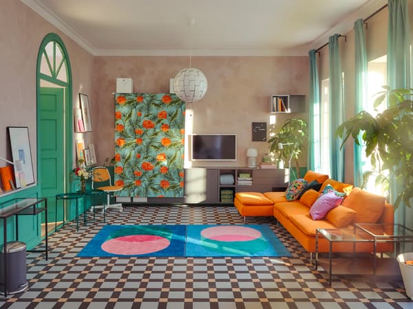 A daytime living room where SÖDERHAMN sofas and other furniture have been either moved to the walls or covered with fabric.