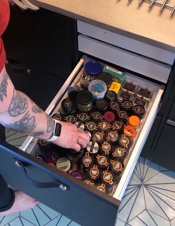 A deep drawer with labelled spice jars and extra inner drawers on top.