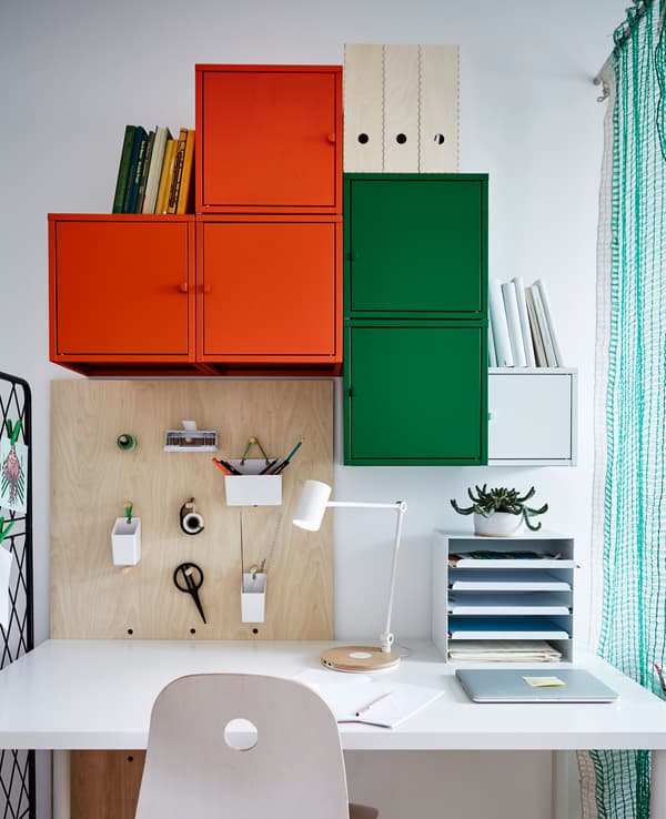 A desk area with lots of storage and a peg board.